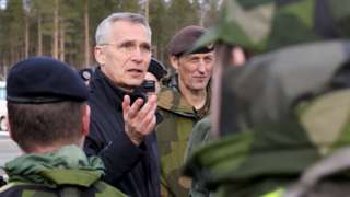 Nato Secretary General Jens Stoltenberg reviews troops during a military exercise