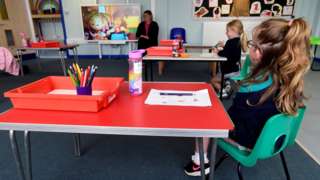 Primary pupils sitting socially distanced in a classroom