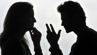 Two people arguing in silhouette