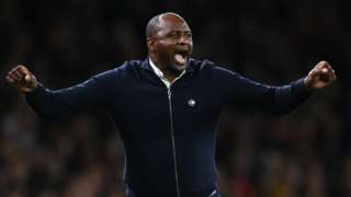 Crystal Palace manager Patrick Vieira celebrates with his arms outstretched and fists clenched