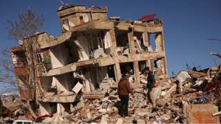 People in front of collapsed building