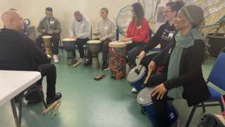 People playing African drums in a lesson