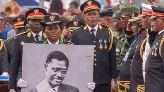 The procession carrying slain Congolese independence hero Patrice Lumumba's only surviving remains arrives at the Limete Tower in Kinshasa on June 30, 2022. -