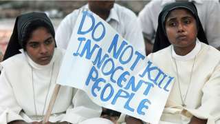 Indian Christian nuns hold a placard as they listen to a speaker during a rally in New Delhi on October 1, 2008 in Karnataka
