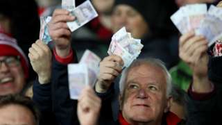 Gloucester fans waved money ate Saracens in reference to their salary cap fine