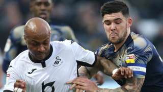 Andre Ayew of Swansea City and Alex Mowatt of Barnsley compete for the ball