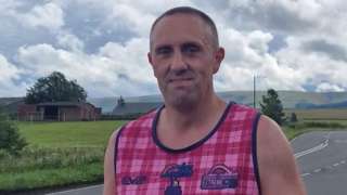 Ben Moorhouse walking along a country road