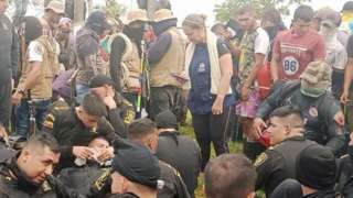 Police officers sit in a circle at a protest in Colombia