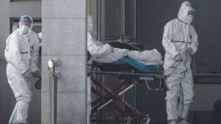 Medical staff carry a patient into the Jinyintan hospital in Wuhan on 18 January 2020.