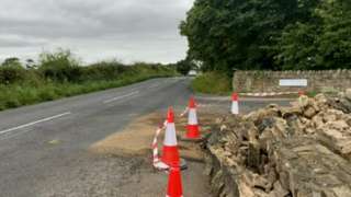 The crash scene with cones around a wall