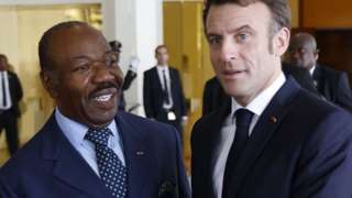 French President Emmanuel Macron (R) is welcomed by Gabon's President Ali Bongo (L)