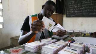 An Ivory Coast Electoral Commission official holds voting cards during distribution of voting cards ahead of the country"s presidential election that will be held on October 31, 2020 in Abidjan, Ivory Coast, 21 October 2020.