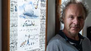 Charlie Mackesy alongside his illustrations