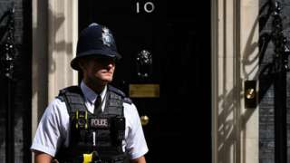 A police officer walks past the front door of No 10, Downing Street