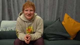 Ed Sheeran sitting on a sofa