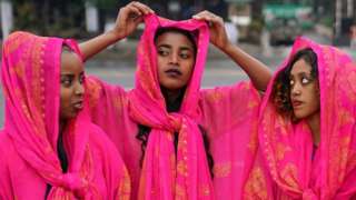 Three women dressed in traditional dresses of the Harari culture of eastern Ethiopia
