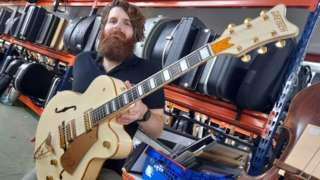 Auctioneer Luke Hobbs with the Gretsch White Falcon guitar