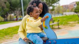 Stock image of a mother playing with a child in the park