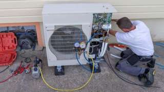 Engineer inspecting heat pump