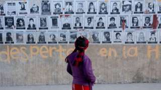 Woman looking at pictures of the disappeared