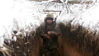 Ukrainian servicemen walk in a trench on their position on the front line with Russia-backed separatists near the small town of Svitlodarsk, in Donetsk