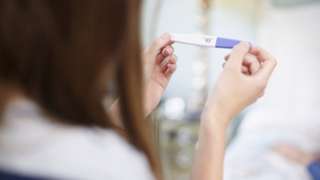 woman holding pregnancy test