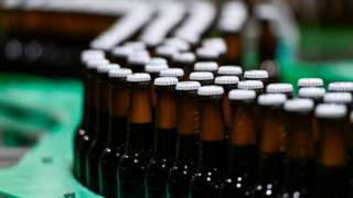 Beer bottles on a conveyor belt at a bottling plant at the Veltins brewery in Grevenstein, western Germany in May 2022