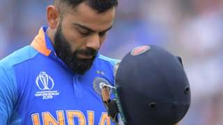 India's captain Virat Kohli leaves the pitch after losing his wicket for 1 run during the 2019 Cricket World Cup first semi-final between New Zealand and India at Old Trafford in Manchester, northwest England, on July 10, 2019.