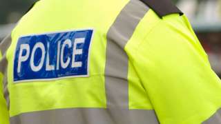 A policeman wearing a high-visibility coat