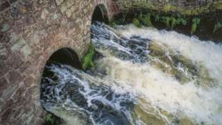 A file photo shows untreated sewage flowing into a river