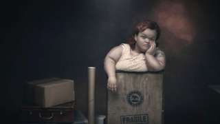 A woman with dwarfism has a bored expression on her face as she stands in a box marked fragile