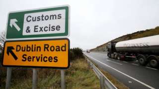 A Guinness lorry passes a sign on a main road outside Newry, Northern Ireland