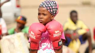 A girl in pink boxing gloves in Lagos, Nigeria - Saturday 5 March 2022