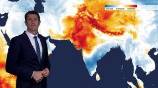 Chris Fawkes in front of a temperature anomaly map of south east Asia