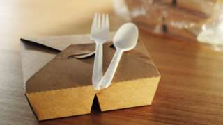 Plastic cutlery on top of a food box