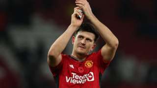 Harry Maguire clapping in a Manchester United shirt on the football pitch