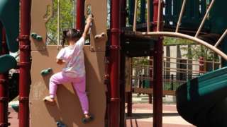A migrant girl who arrived with her family from Venezuela plays in a Chicago playground