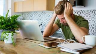Man looking at laptop stressed