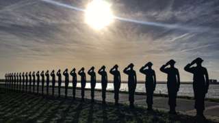 Wooden statues (26 in total) reflected by water at Purfleet-on-Thames in Essex