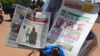 A street vendor sells local newspapers in Ouagadougou on October 5, 2022 which headline the September 30 military coup