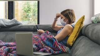 Woman wearing mask on sofa
