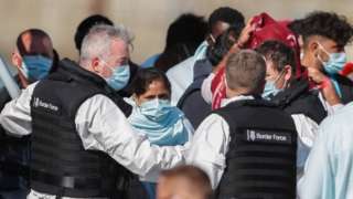 UK Border Force officials working with migrants brought into Dover harbour on Thursday