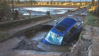 A car stuck after a bridge was washed away following torrential rain on October 21, 2023 in Dundee