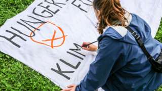 An activist supporting a group of others on a hunger strike is creating a banner at a climate camp near the Reichstag building on September 12, 2021 in Berlin, Germany.