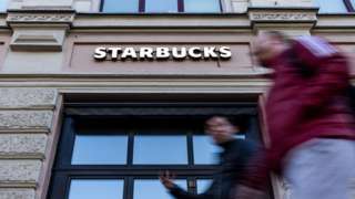 people walk past Starbucks in Moscow