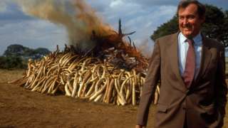 Paleontologist and conservationist Richard Leakey in front of a haul of burning ivory