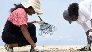Two female volunteers collect plastic debris into rubbish bags at Lighthouse Beach near Lagos, Nigeria - Saturday 27 March 2021