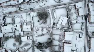 Aerial view of snow-covered houses in Oulton, Staffordshire