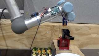 Arm of "robot chef" puts food into press