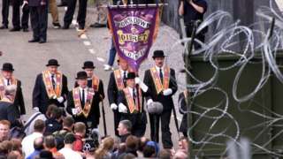PACEMAKER BELFAST 4/7/99 Orangemen and supporters surver the mass of razor wire in the fields surrounding Drumcree church preventing them from marching down the Garvaghy road on Sunday afternoon.